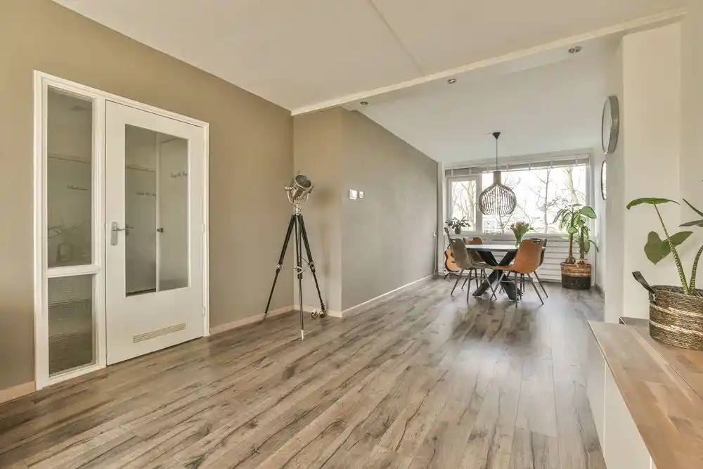 Geniş pencereli, yemek masası ve bitkiler bulunan aydınlık modern iç mekân